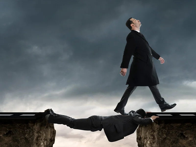 Businessman walking toward the edge of a cliff